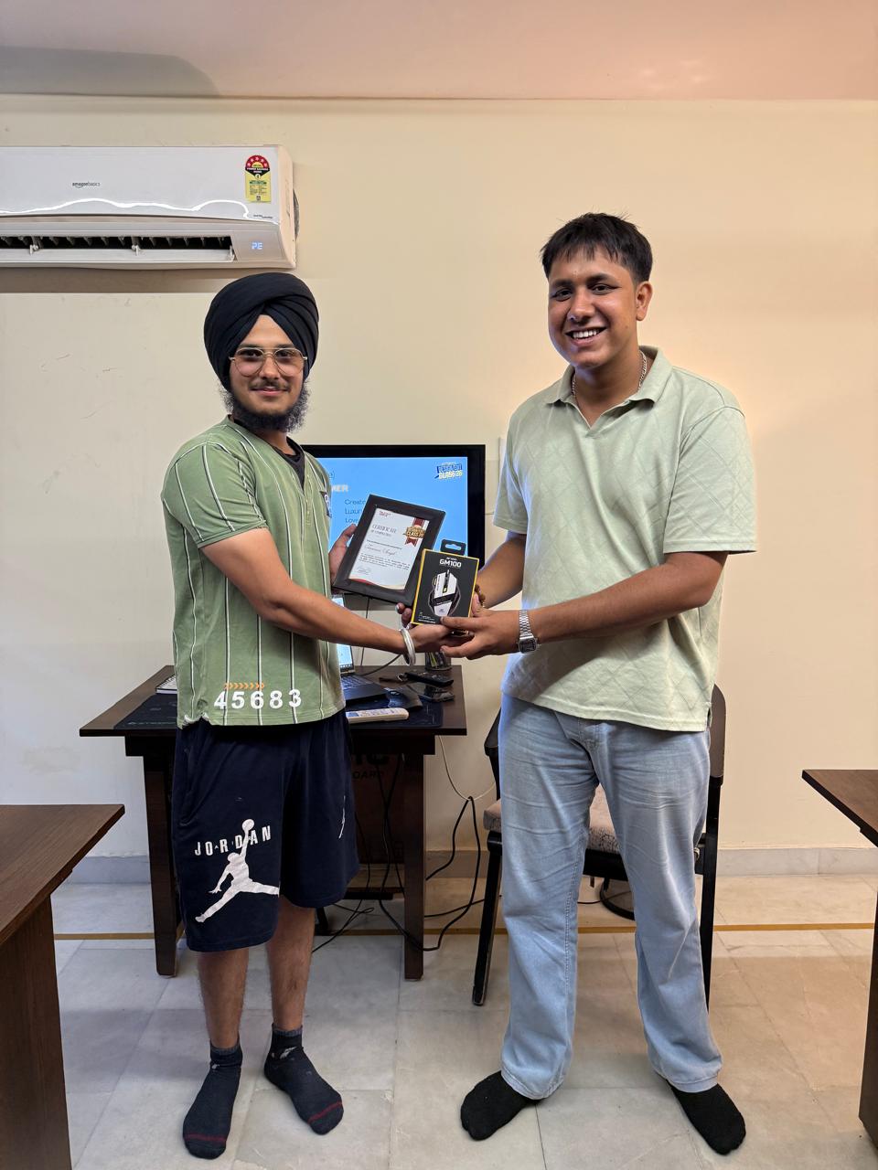 Graduate receiving a certificate and a gift at Design/Edit Class 26
